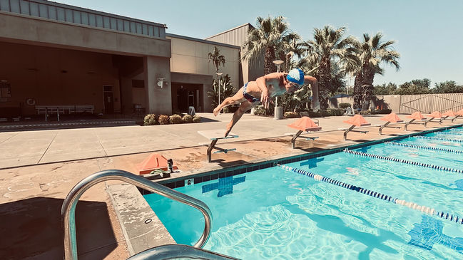 Competitive swimmer diving off block